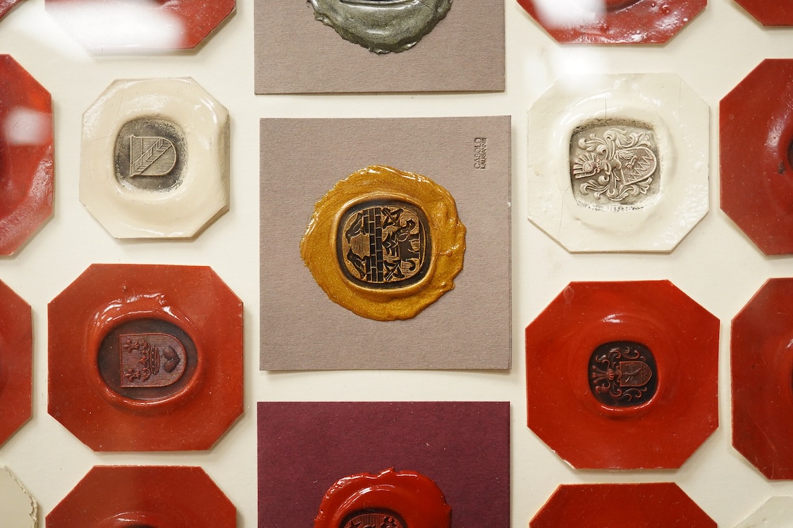 A framed display of red and white wax seals, some stamped Casolo Lausanne, 95 in total, 59cm wide
